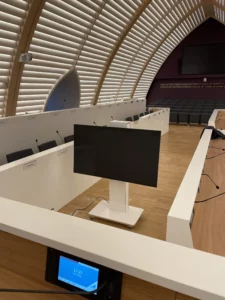 Salle du conseil municipale de La Rochelle équipée d'un système audiovisuel moderne avec écran central et interfaces numériques intégrées