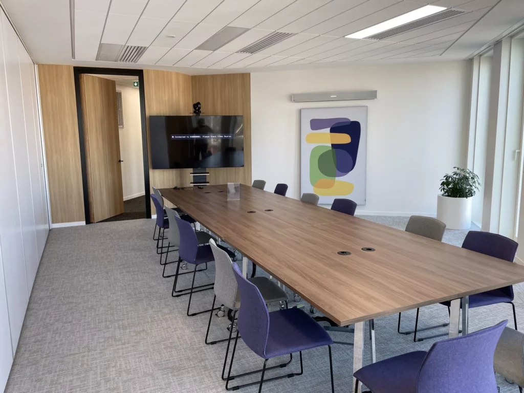 Salle de visioconférence IRIS équipée de matériel Teams Room avec système Logitech, écran Nureva et caméra Aver sur pied, solution Barco ClickShare CX-30/CX-50