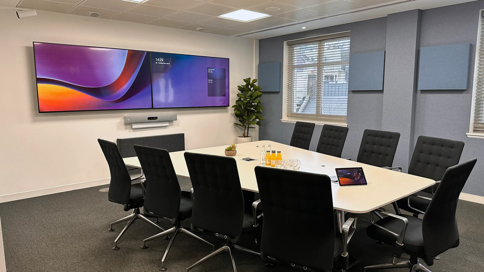 Salle de réunion équipée Microsoft Teams avec double écran, table de conférence professionnelle, système de projection et caméra pour visioconférences d'entreprise